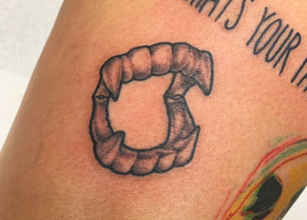 Vampire teeth tattoo
