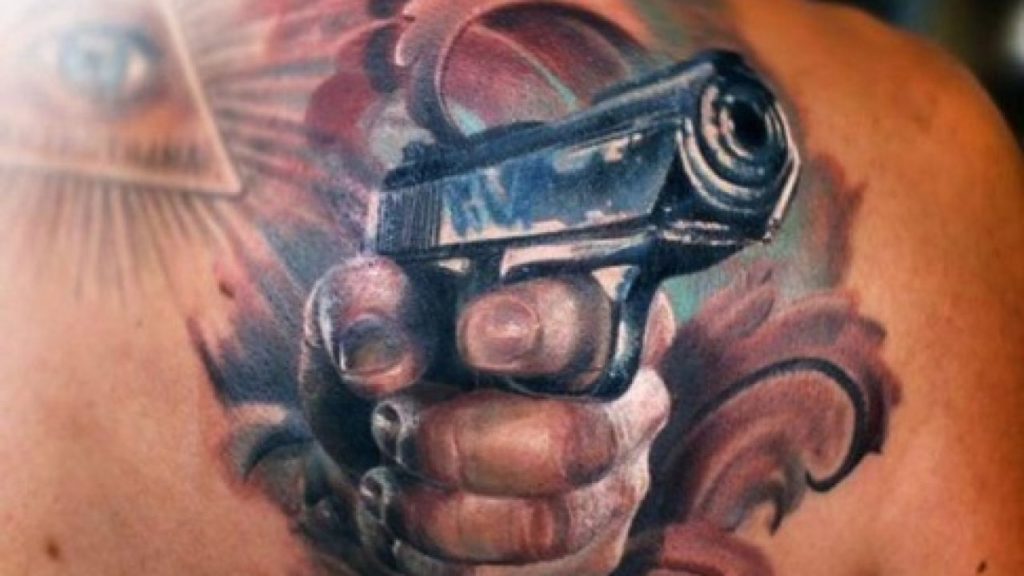 gun tattoo on thigh