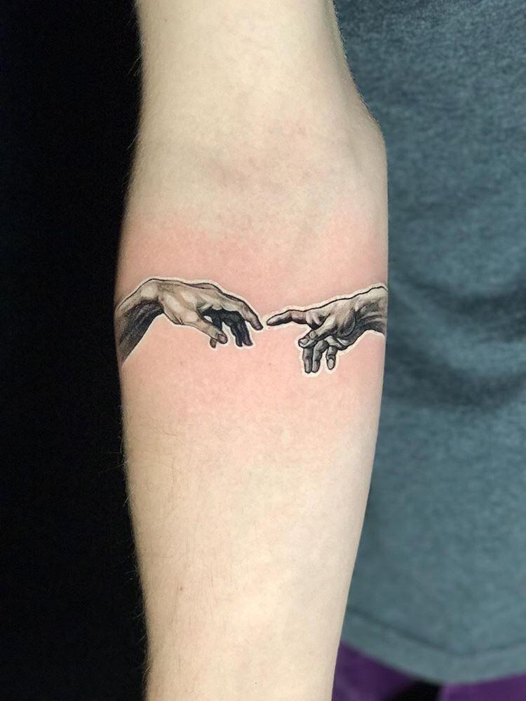creation of adam hands tattoo