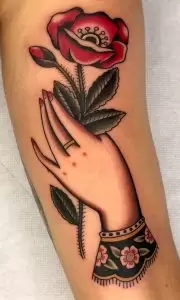 hand holding flowers tattoo