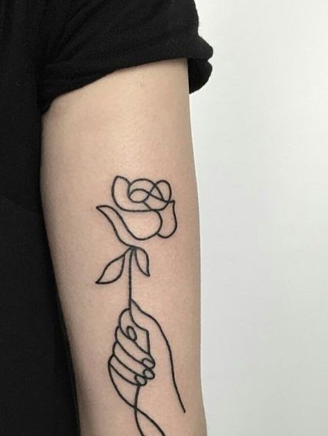 hand holding flowers tattoo
