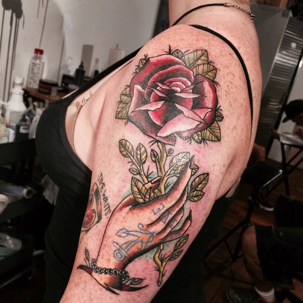 hand holding rose tattoo